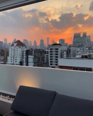 Rooftop balcony with a city skyline view during sunset