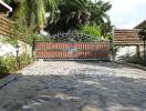 Main entry gate with stone-paved driveway