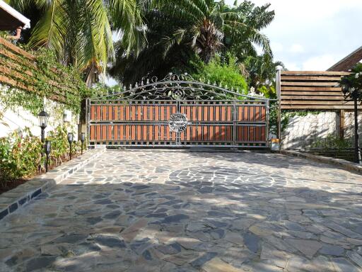 Main entry gate with stone-paved driveway