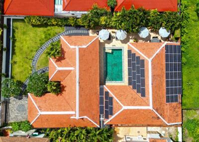 Aerial view of a building with a pool and solar panels on the roof