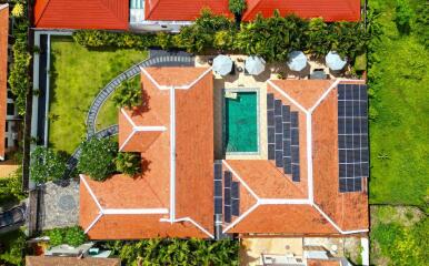 Aerial view of a building with a pool and solar panels on the roof