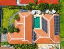 Aerial view of a building with a pool and solar panels on the roof