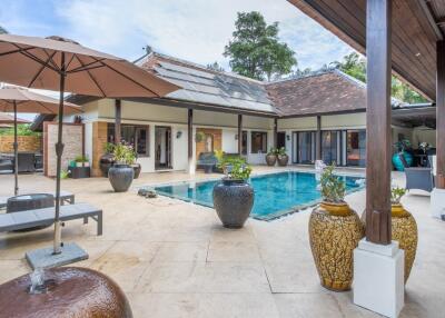 Luxurious outdoor pool area with lounge chairs and potted plants