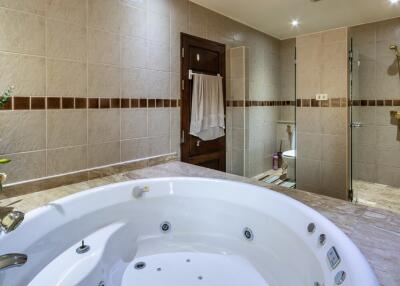 Spacious bathroom with a Jacuzzi tub, shower, and modern amenities