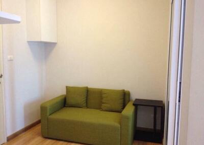 Small living area with green sofa and side table