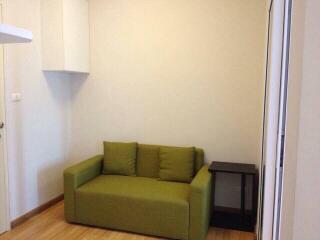 Small living area with green sofa and side table