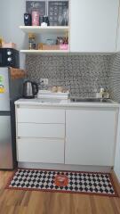 Compact kitchen with white cabinets and mosaic tile backsplash