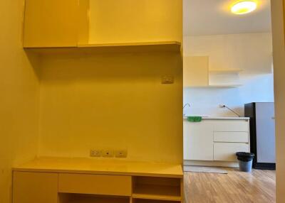 View of a kitchen with light yellow cabinets and wooden flooring