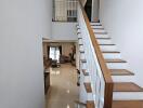 Bright and spacious interior staircase leading to an upper level overlooking a modern living area