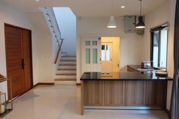 Modern kitchen area with wooden cabinetry and breakfast bar