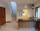 Modern kitchen area with wooden cabinetry and breakfast bar