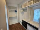 Spacious walk-in closet with built-in shelves, drawers, and a mirror