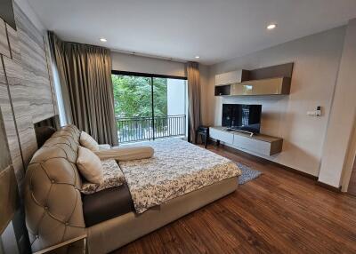 modern bedroom with a large bed, built-in storage, and a large window