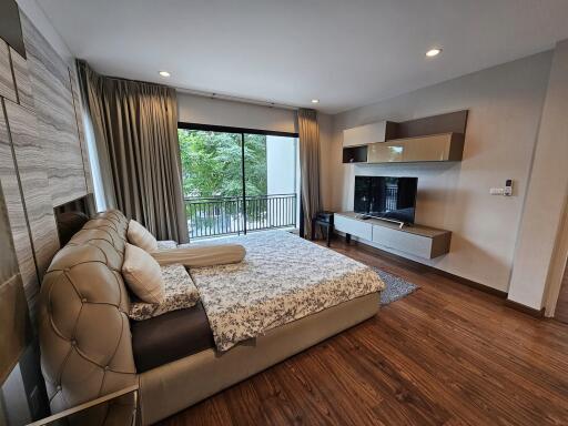 modern bedroom with a large bed, built-in storage, and a large window