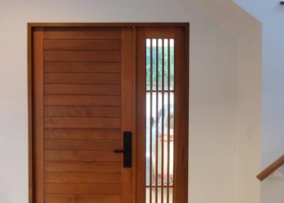 Well-lit entryway with modern wooden door