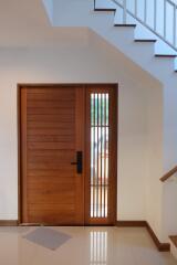 Well-lit entryway with modern wooden door