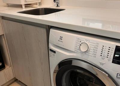 Laundry room with washing machine and sink