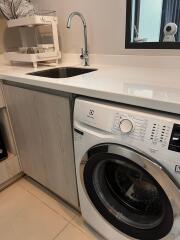 Laundry room with washing machine and sink