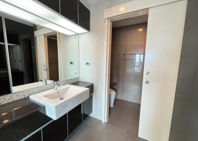 Modern bathroom with sink and sliding door to toilet area