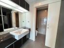 Modern bathroom with sink and sliding door to toilet area