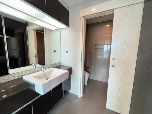 Modern bathroom with sink and sliding door to toilet area