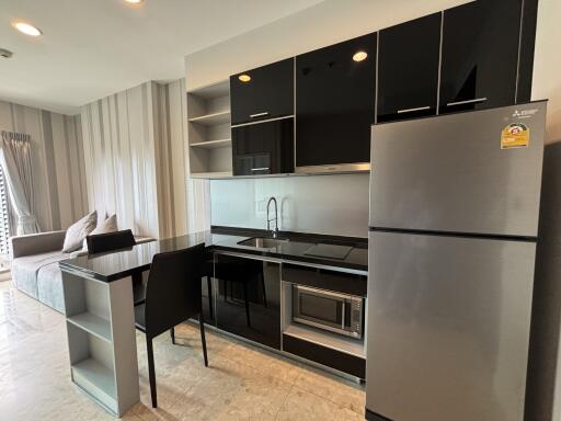 Modern kitchen area with black appliances and adjacent living space