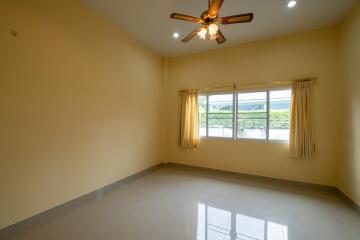 Empty bedroom with ceiling fan and large window