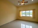 Empty bedroom with ceiling fan and large window