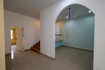 Main living space with archway, stairs, and adjoining rooms