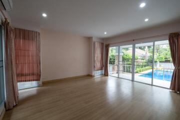 Spacious living room with large windows and pool view