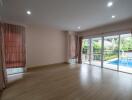 Spacious living room with large windows and pool view