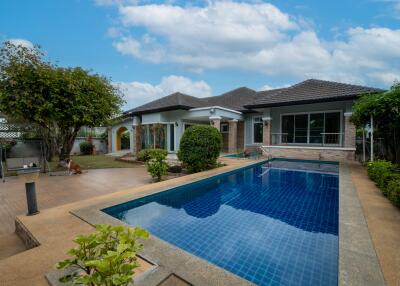 Outdoor area with a swimming pool and a house in the background