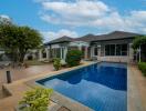 Outdoor area with a swimming pool and a house in the background