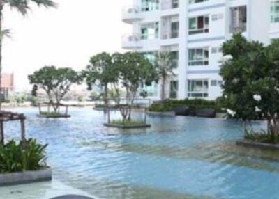 Outdoor pool area with modern apartment building in the background