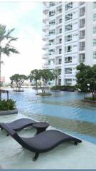 Outdoor pool area with modern apartment building in the background