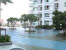 Outdoor pool area with modern apartment building in the background