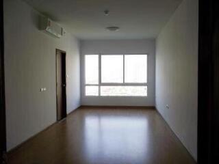 A spacious empty living room with a large window