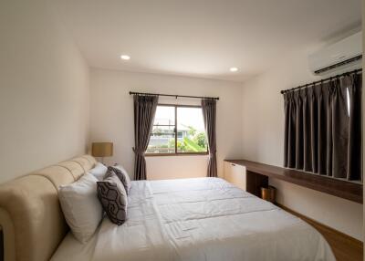 Well-lit bedroom with double bed and large window