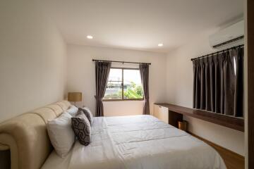 Well-lit bedroom with double bed and large window