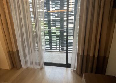 Living area with a sliding door leading to a balcony with wooden blinds