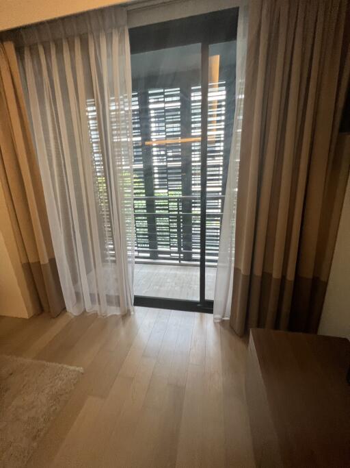 Living area with a sliding door leading to a balcony with wooden blinds