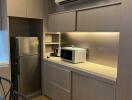 Modern kitchen with wooden cabinets, built-in microwave, refrigerator, and air conditioner