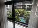 View of building and greenery through window