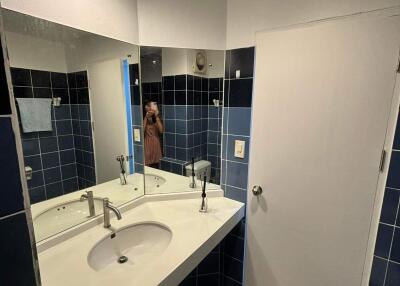 Bathroom with white countertop and blue tiled walls