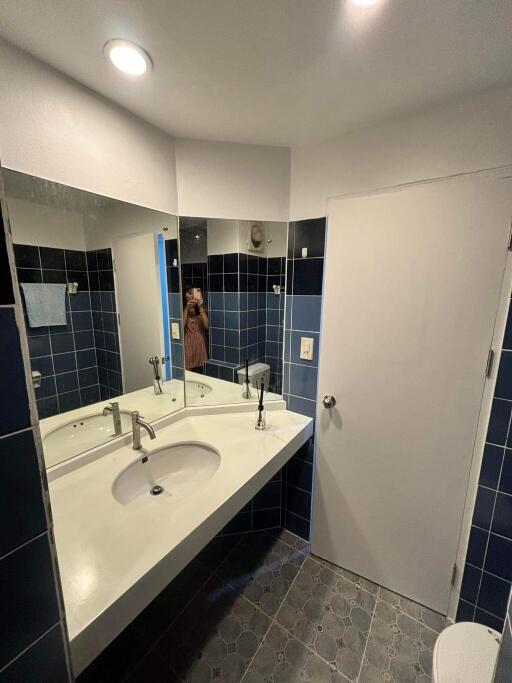 Bathroom with white countertop and blue tiled walls