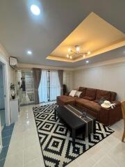 Modern living room with brown sofa and geometric rug