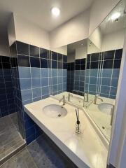 Modern bathroom with blue tiled walls and a white sink