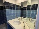 Modern bathroom with blue tiled walls and a white sink