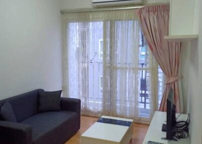 Living room with sofa, coffee table, TV, and balcony view