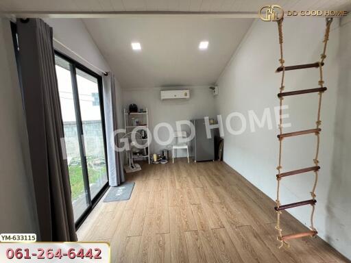 Spacious room with wooden flooring and sliding glass doors